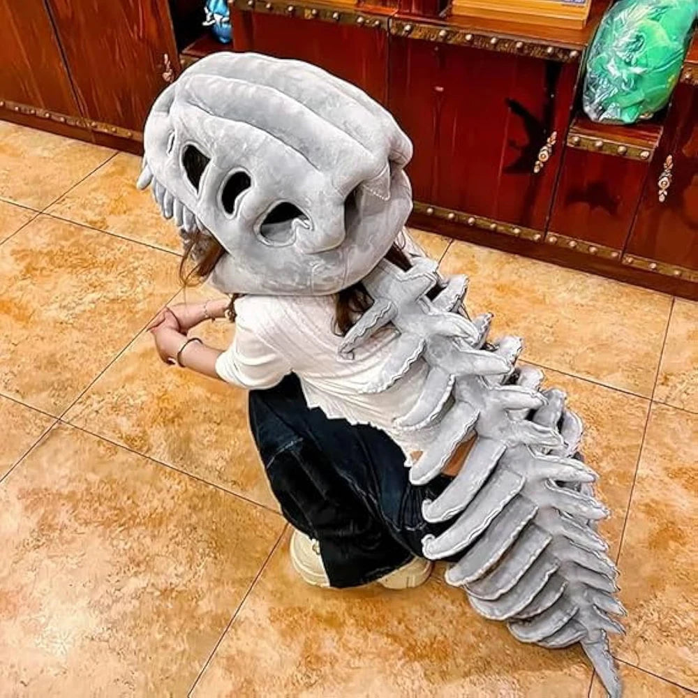 A person wearing a gray dinosaur skeleton costume with large skull features and a long, textured tail.