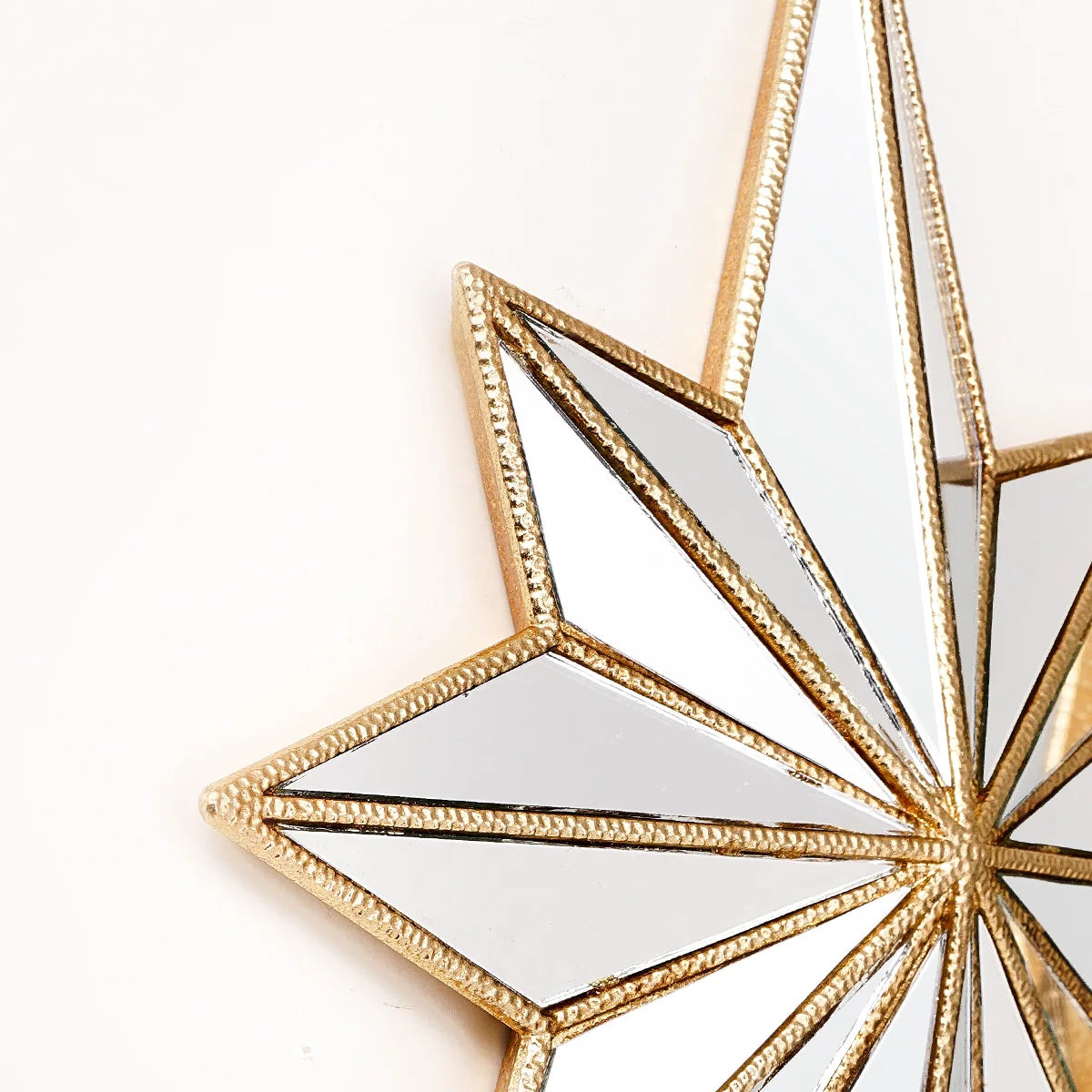 Nahaufnahme eines dekorativen Harzsterns Wanddekoration mit goldfarbenen geometrischen Facetten.