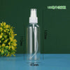 A clear glass bottle with a white pump dispenser and a white cap, shown next to a sprig of yellow-green foliage.