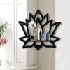 Estante de madera negra decorativo con cristales y flores blancas y azules sobre una pared blanca.