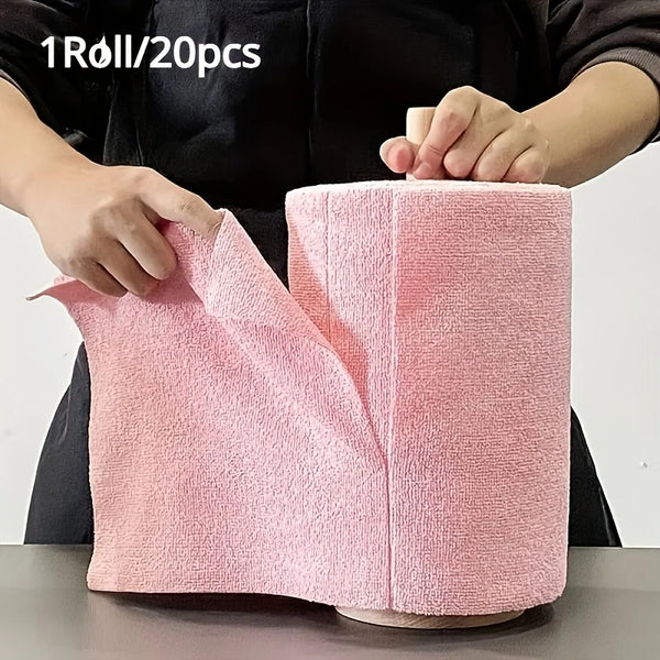 A hand is holding a roll of pink reusable microfiber cleaning cloths, showing the texture and size.