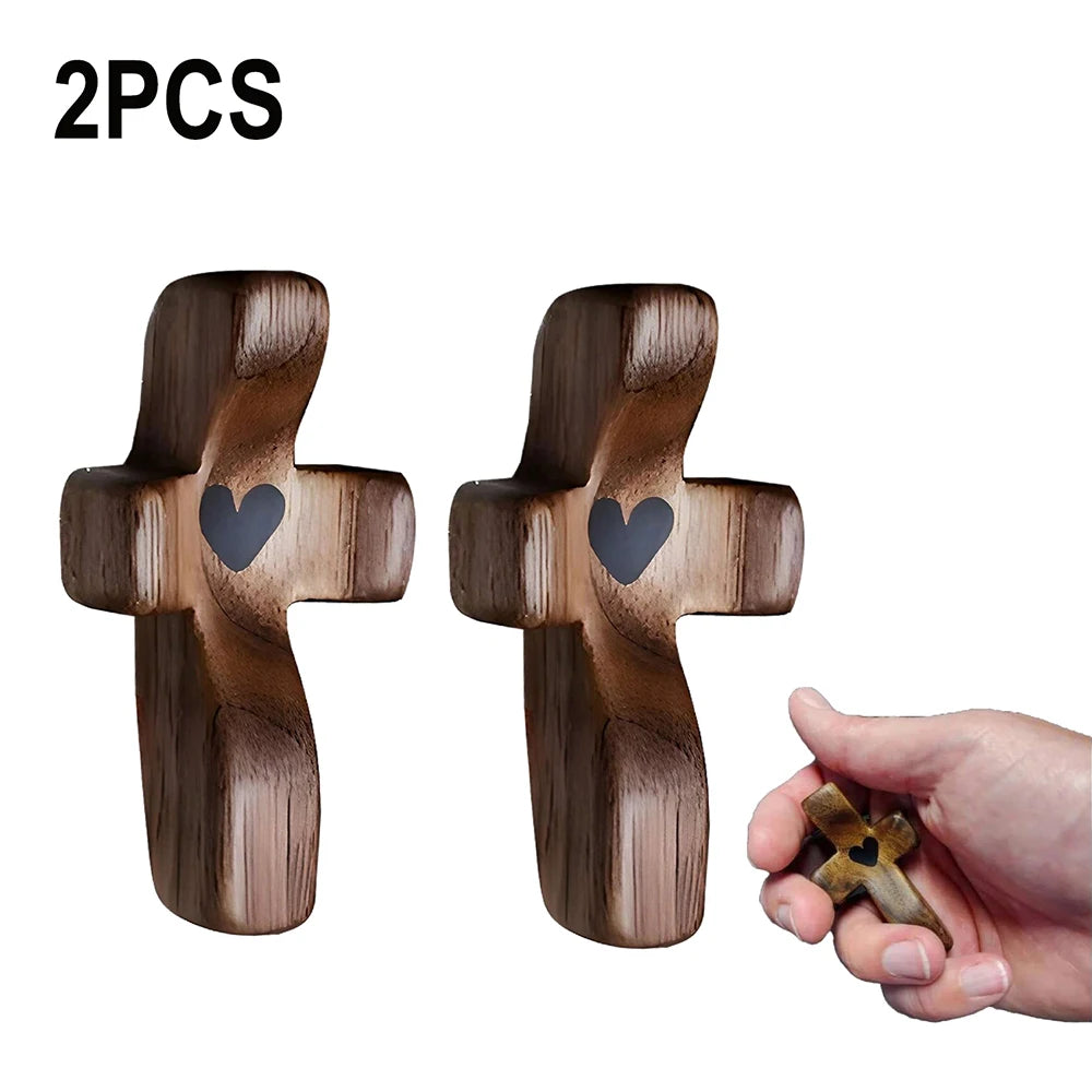 Two handcrafted wooden pocket crosses with heart engravings shown against a white background.