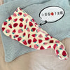 A pink and white strawberry print quick-drying hair towel headscarf is displayed on a light blue knitted fabric.