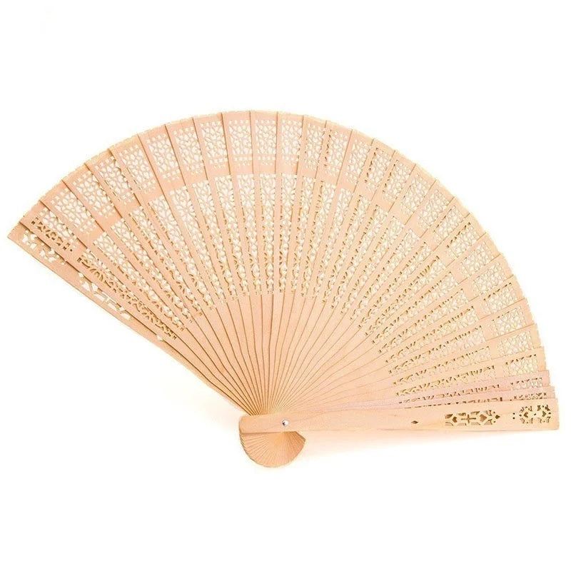 Un ventilateur pliable en bois clair avec des motifs perforés délicats, montré ouvert et anglé.