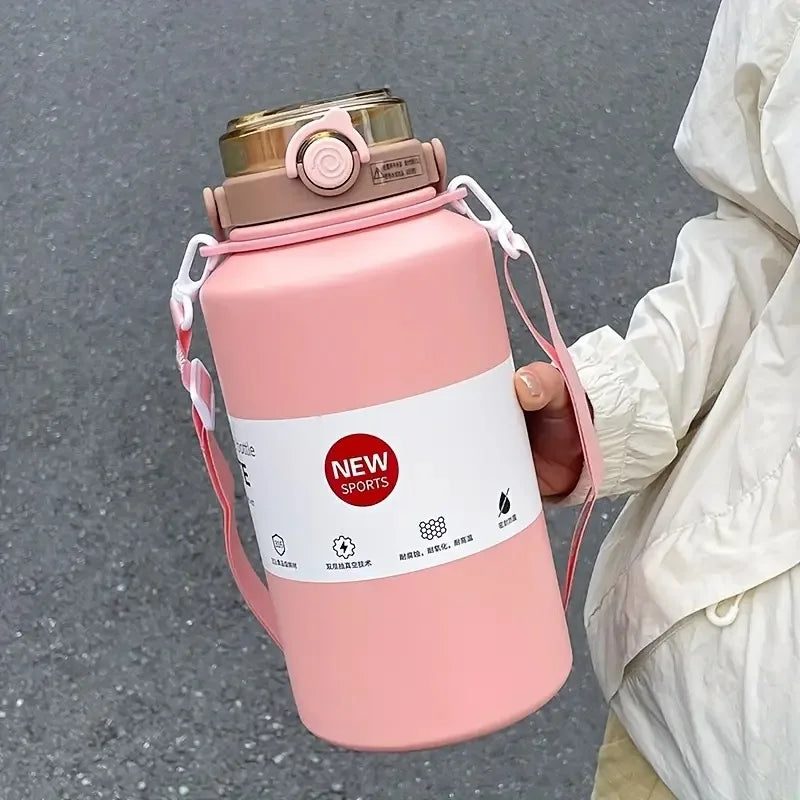 A pink insulated tumbler with a lid and straw is held by a person against a gray background.
