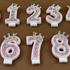 Ein Set dekorativer Strassenkuchenkerzen in Form der Zahlen 0 bis 9 in rosa und weiß.