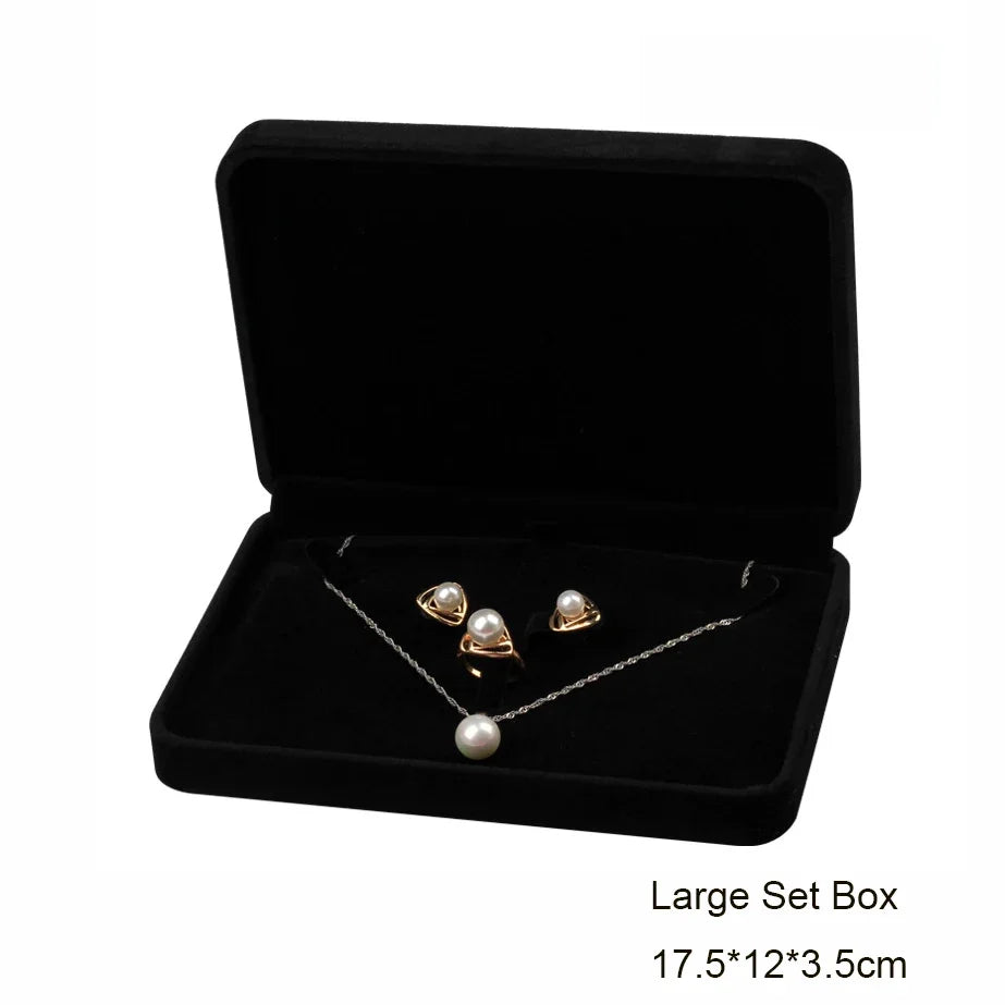 Elegant black velvet jewelry storage box set with a silver necklace and pearl earrings