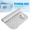 A silver quilted ironing mat with a rolled cloth and a steam iron placed on it.