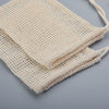 A set of natural beige cotton mesh soap saver pouches with drawstring ties.