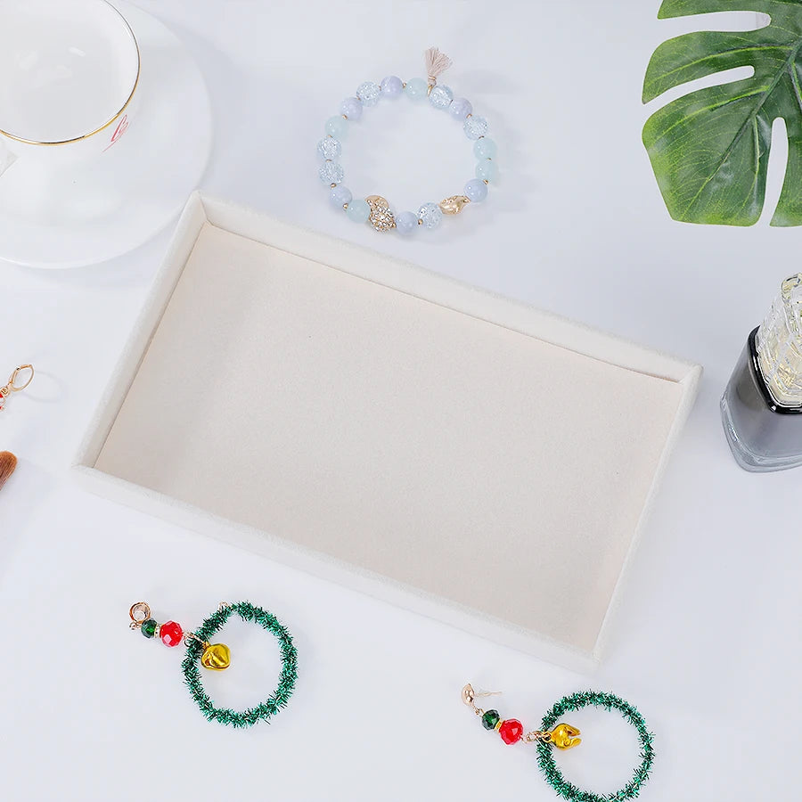 A velvet jewelry organizer tray with a drawer is shown, containing various beaded bracelets and jewelry items.
