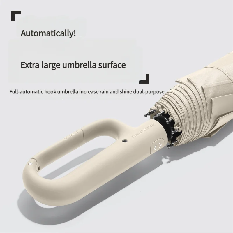 A close-up view of a beige windproof automatic folding umbrella with a large surface and hook.