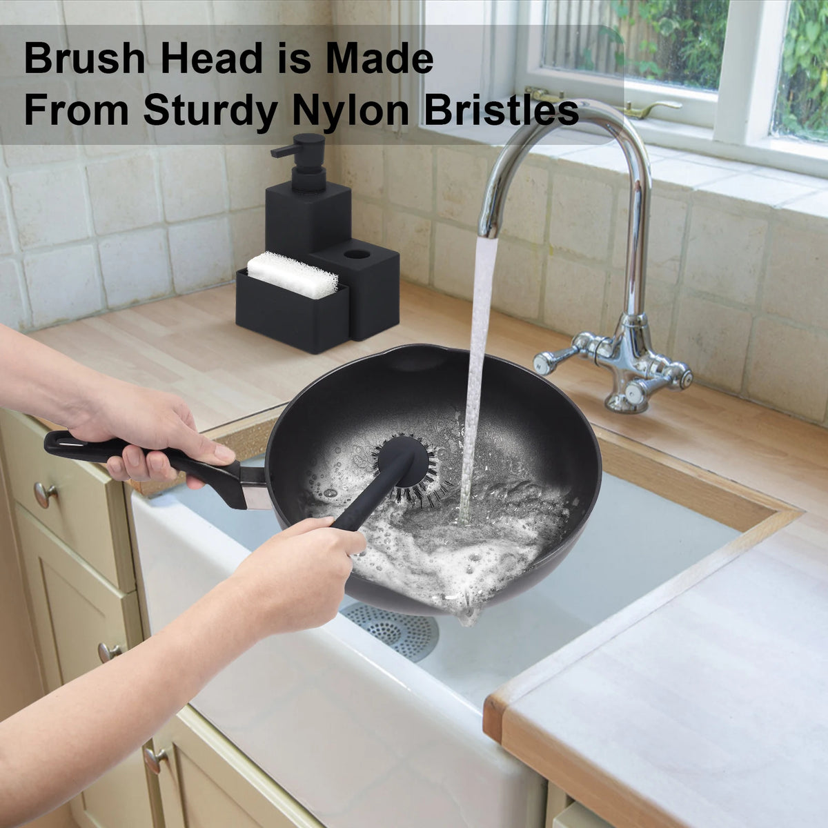 Hands are cleaning a black frying pan with a brush head made from sturdy nylon bristles.