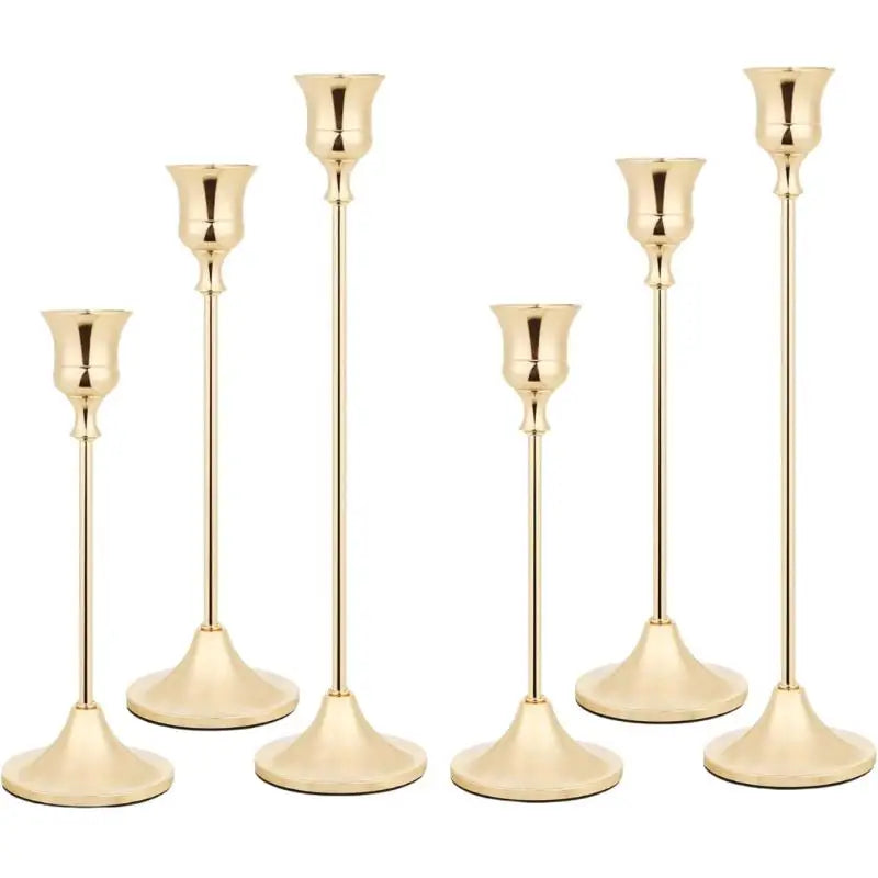 A set of three elegant brass metal candle holders with slender stems and flared bases.