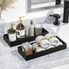 A set of black silicone trays organizing soap and bathroom products on a marble countertop.