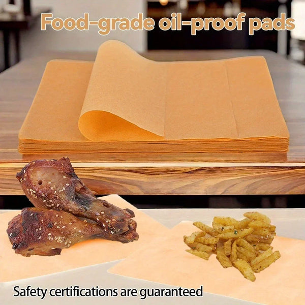 A stack of food-grade oil-proof parchment paper next to cooked chicken and fried potatoes.