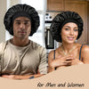 A man and a woman wearing black silk sleep caps looking at the camera.