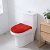 A white toilet with a bright red protective seat cover placed on it in a bathroom setting.