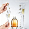 A hand is using a clear roller liquid guide massage comb to dispense essence onto a hair growth serum bottle.