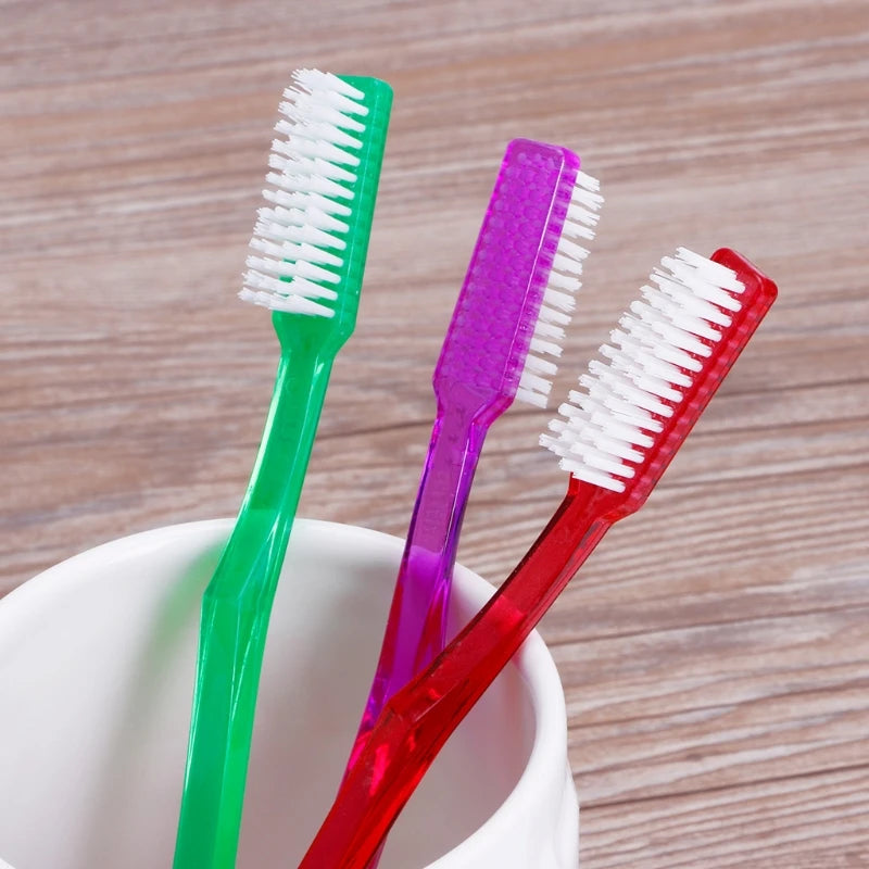Una colección de seis cepillos de dientes de cerdas duras premium en varios colores, incluyendo verde, morado y rojo, sobre u