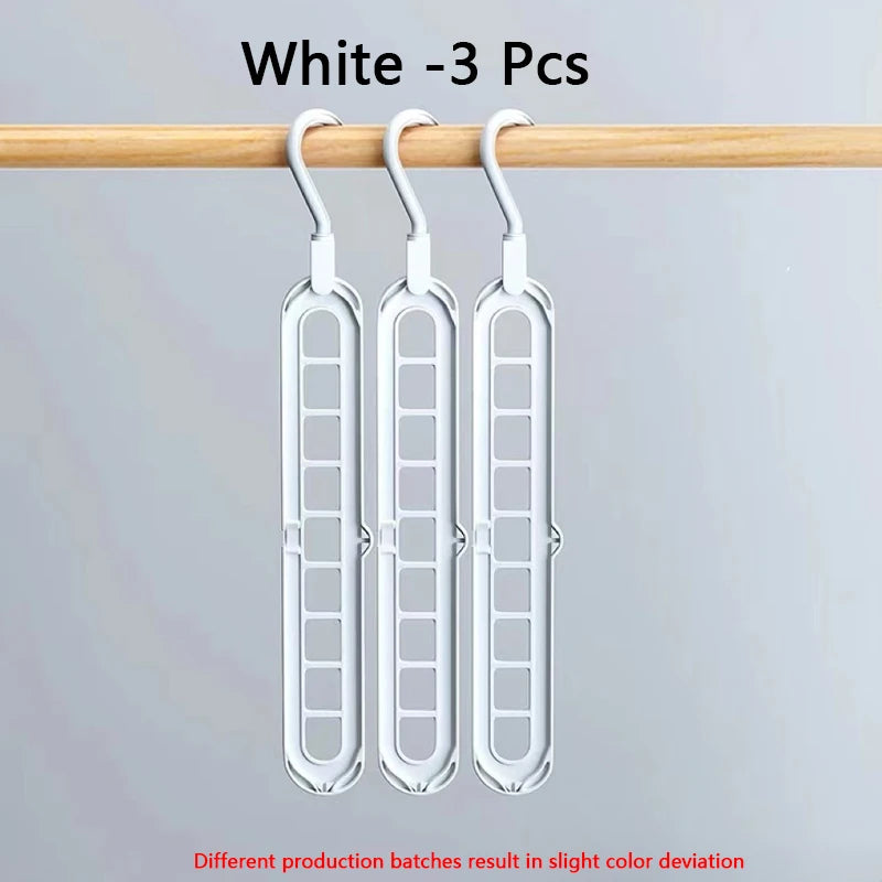 Three white space-saving clothes organizer hangers hanging from a wooden rod.