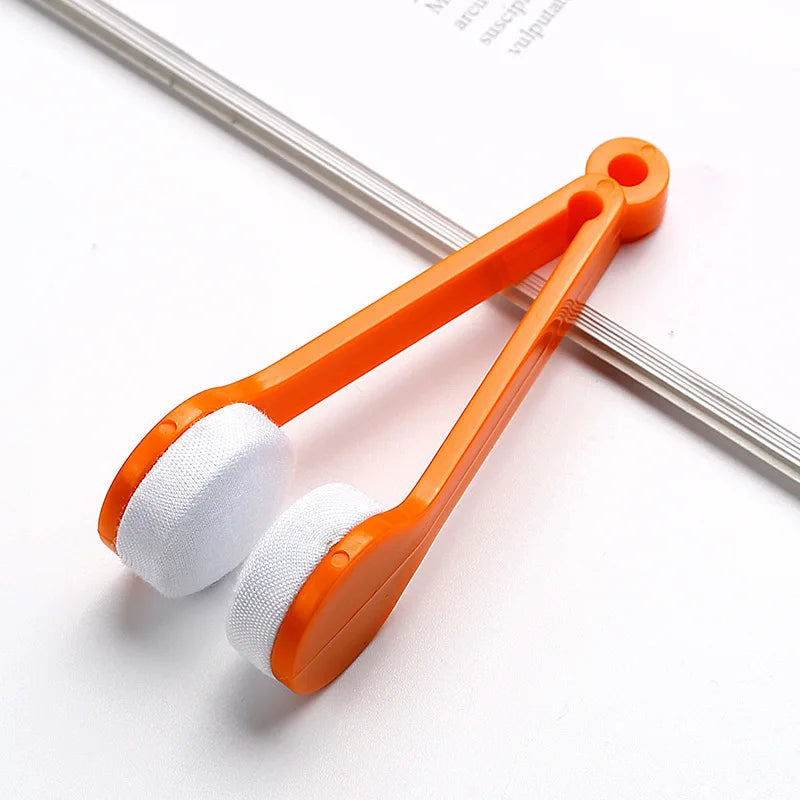 Orange plastic tool with white foam cleaning pads for eyeglasses