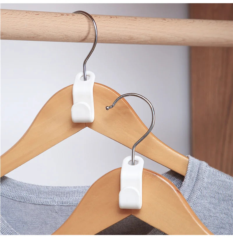 Nahaufnahme weißer Mini-Kleiderhaken, die an einem Holzhaken hängen.