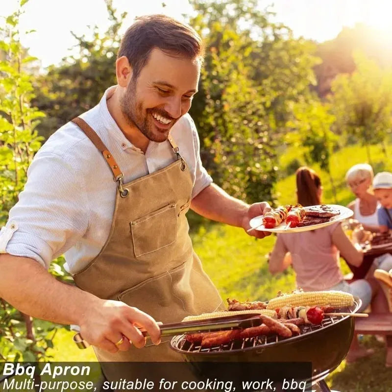A man wearing a tan oil-proof canvas apron is grilling food outdoors in a sunny garden setting.