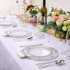 Silberbesteck mit Spitze, dekorative Einwegpartyteller auf weißem Tischtuch mit Blumenarrangements.