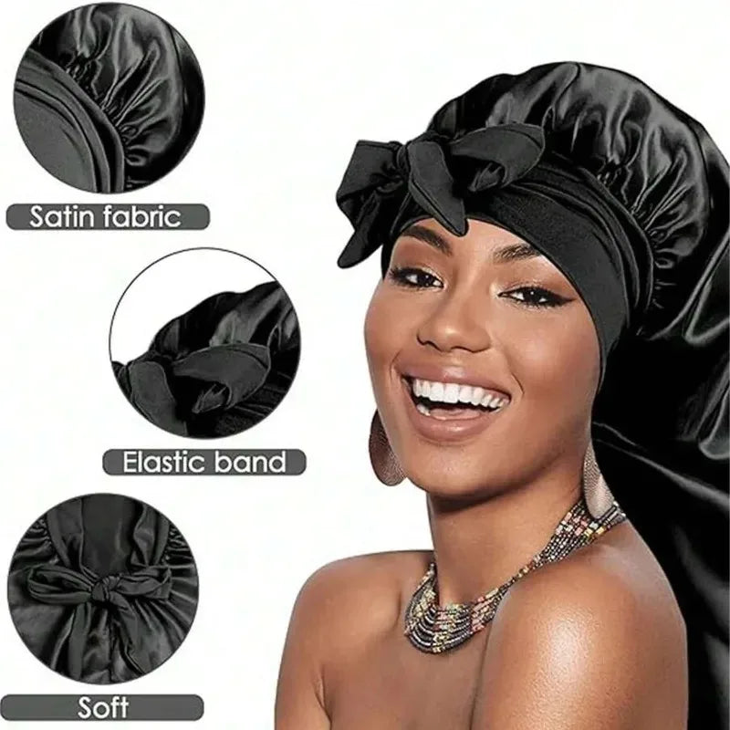 A woman wearing a black satin sleeping bonnet tied in a bow, highlighting the soft fabric and elastic band.