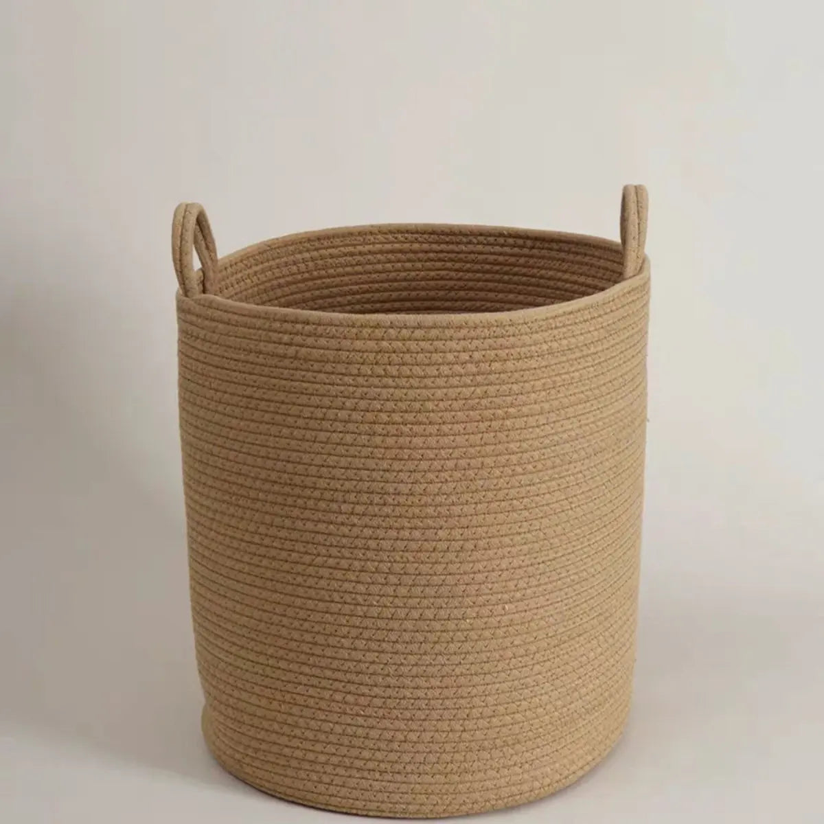 A beige natural cotton rope storage basket with a woven texture.