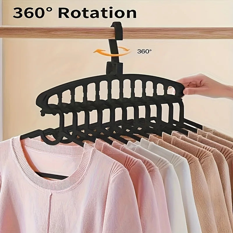 Black plastic hangers with a 360 degree rotation feature hanging on a wooden rod.