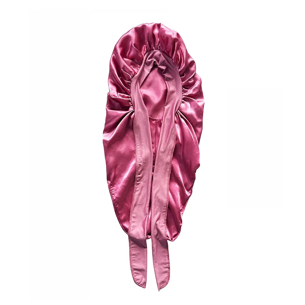 A satin sleeping bonnet in a dusty rose color, designed for curly hair.