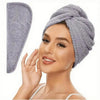 A woman is wearing a gray microfiber hair towel wrap on her head.