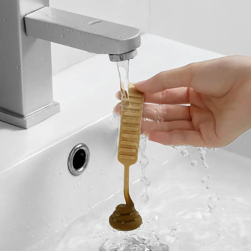 A hand is using a portable toilet lid lifter to lift and drain water from a faucet.