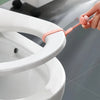 A hand is using a silicone ring opener to lift or adjust the rim of a white toilet seat.