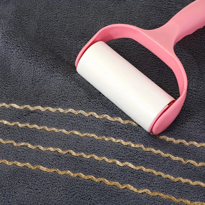A pink plastic towel hanger holds a roll of white coral fleece towel with gold stripes on a dark gray towel.