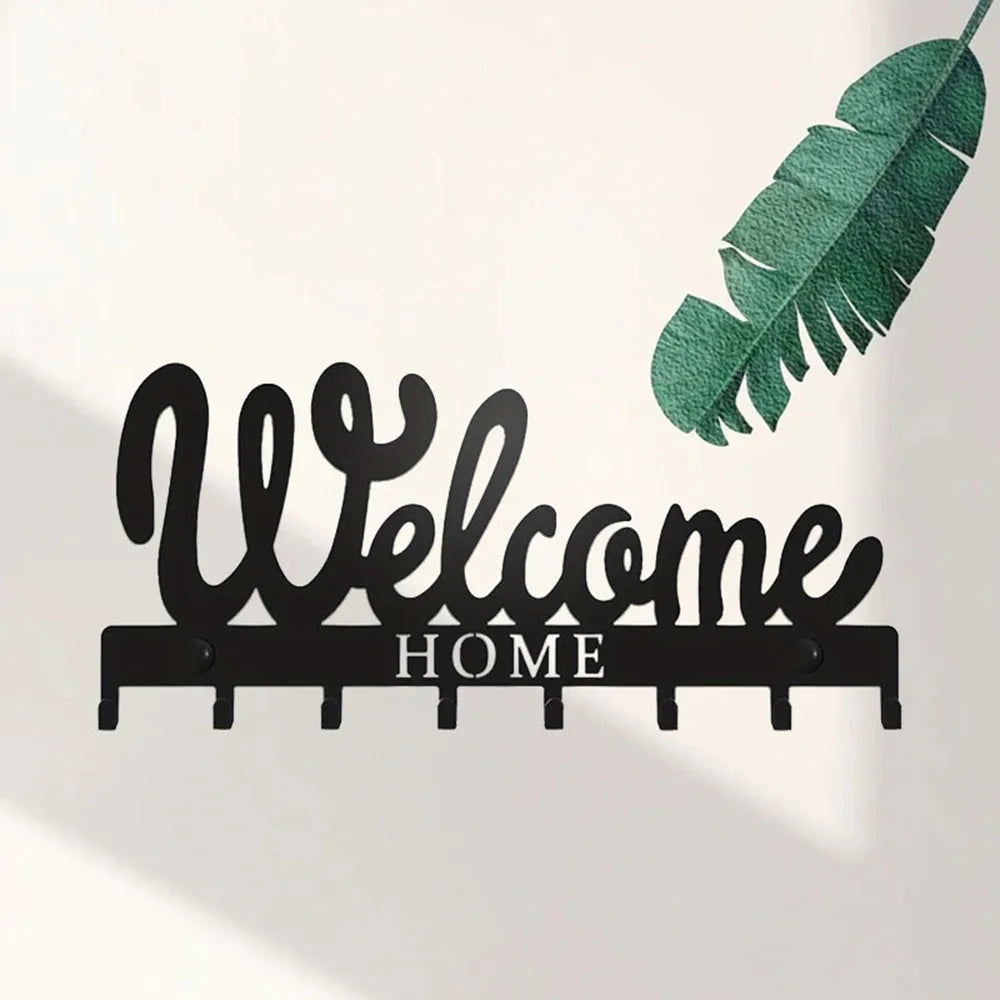 Black decorative metal key holder rack with hooks and a green leaf design