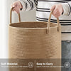A person is holding a large woven storage hamper made of natural fiber with handles.