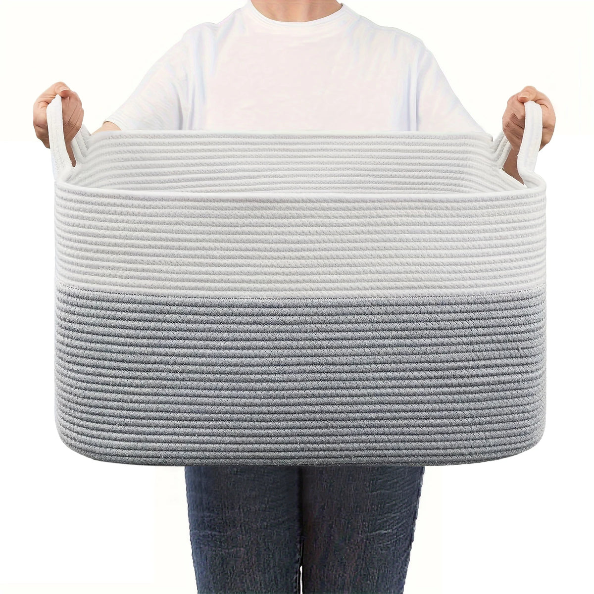 A person holds a gray woven cotton storage basket with a white shirt.