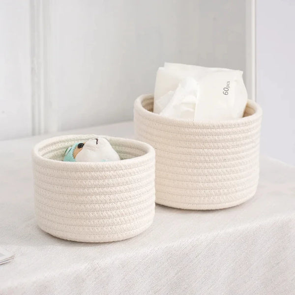 A natural beige handwoven cotton rope storage basket filled with white tissue paper.