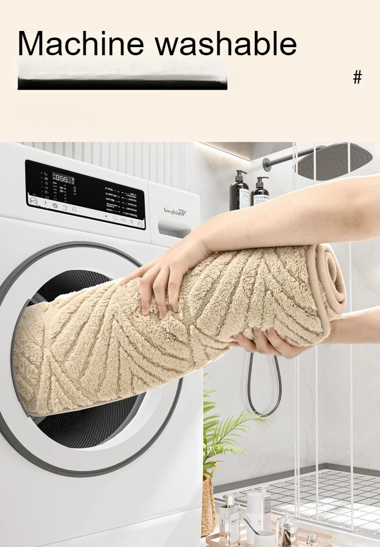 A hand is pulling a beige plush non-slip bathroom rug out of a white washing machine drum.
