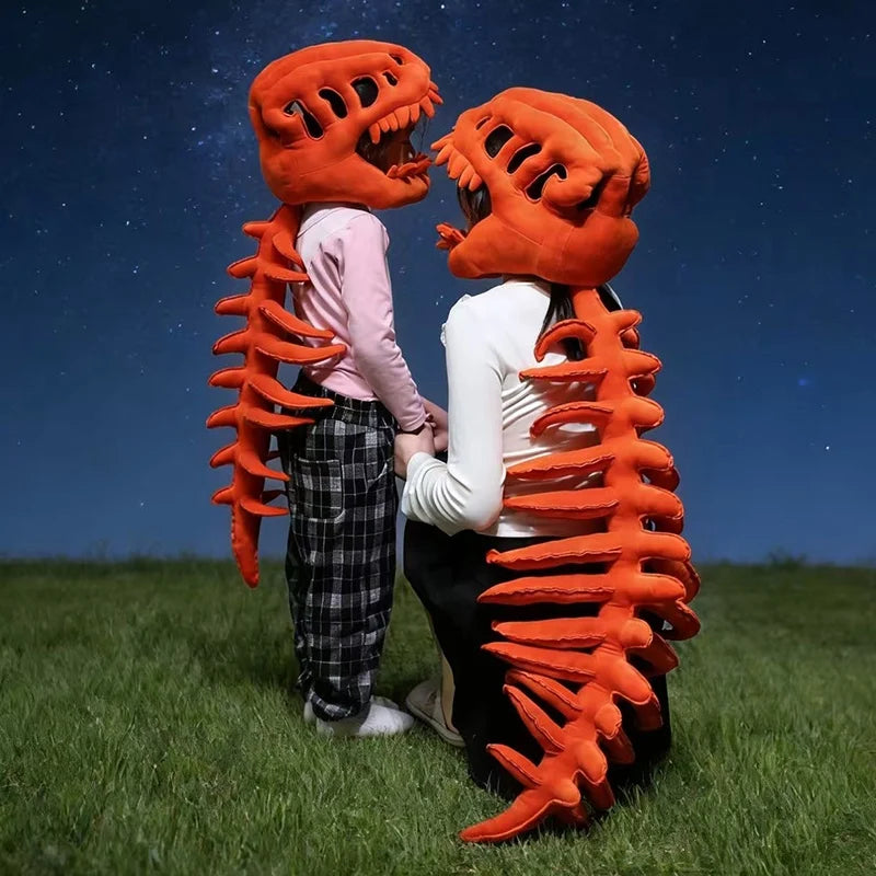 A pair of realistic dinosaur skeleton costumes, orange and pink, standing in a grassy field under a starry night sky.
