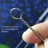 A hand holds a stainless steel straw cleaning brush with a loop handle, demonstrating its strong and bendable nature.
