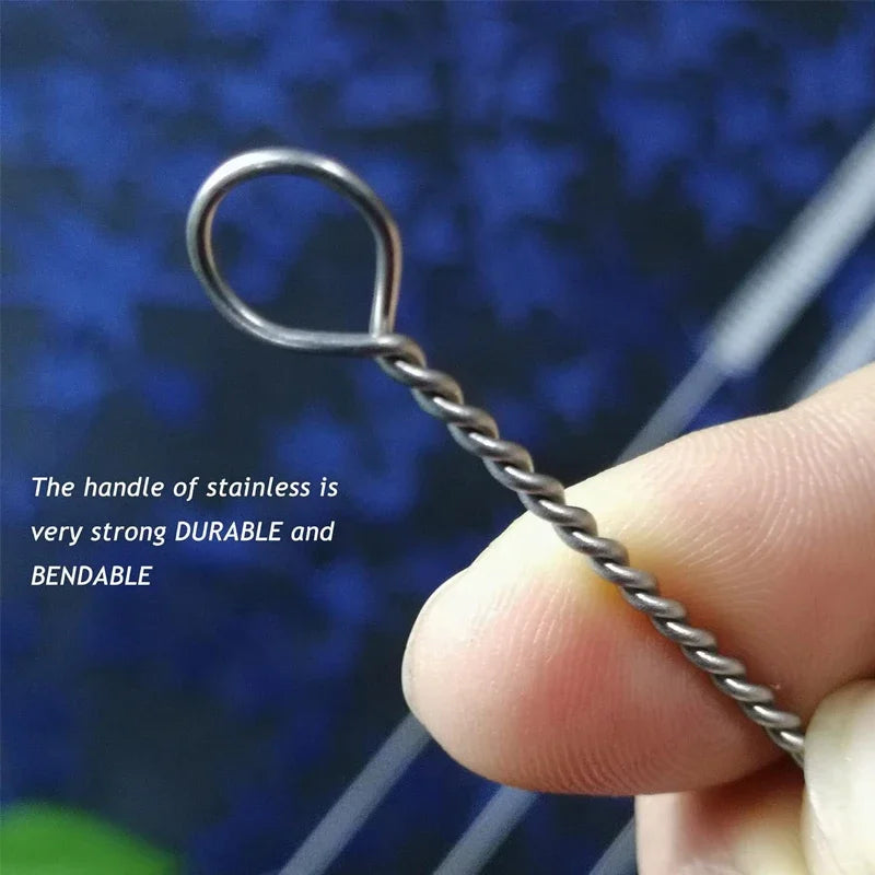 A hand holds a stainless steel straw cleaning brush with a loop handle, demonstrating its strong and bendable nature.