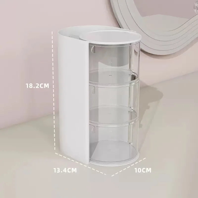 A white acrylic rotating organizer with three clear circular compartments for hair accessories and makeup.