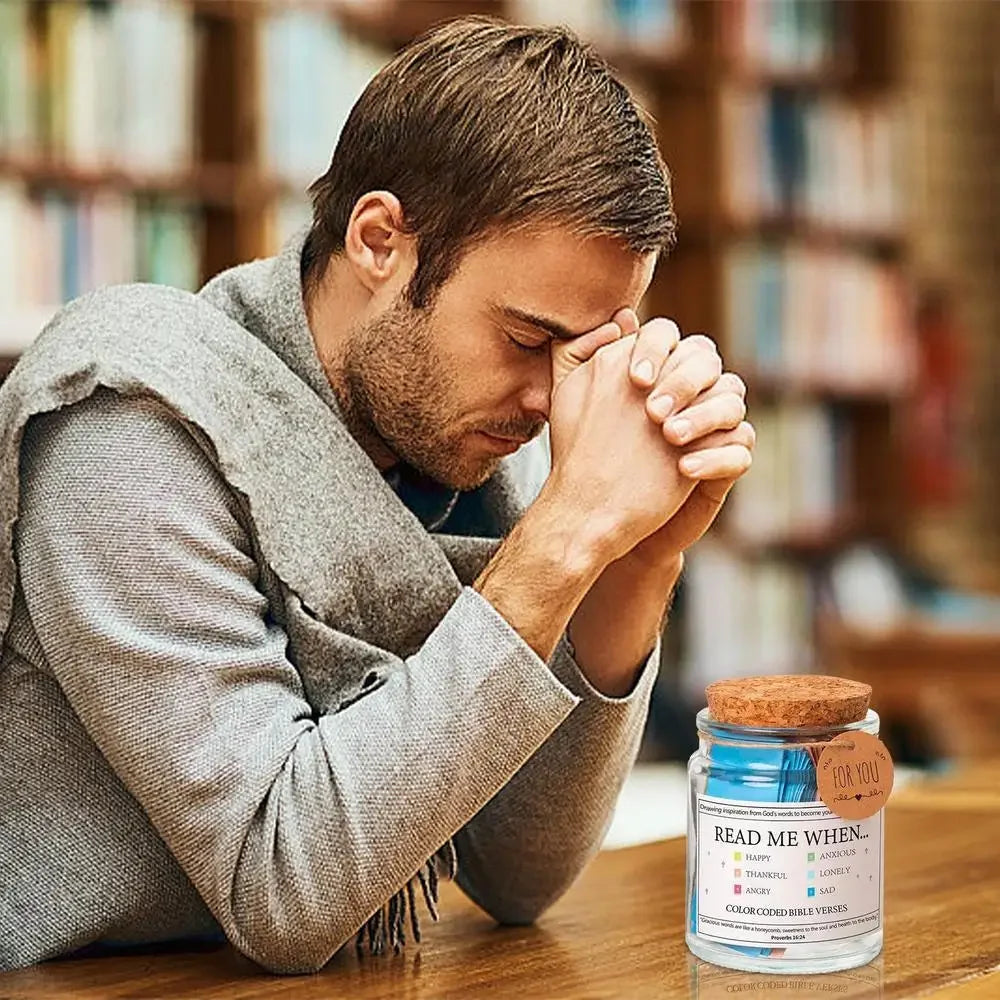 A man is looking down with his hands clasped in prayer next to a jar labeled for you Read Me When.