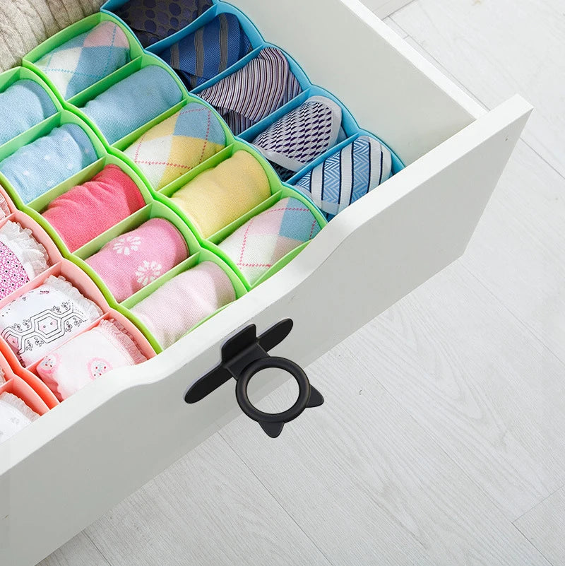 A white cabinet door features silicone self-adhesive lifters in various pastel and striped colors.