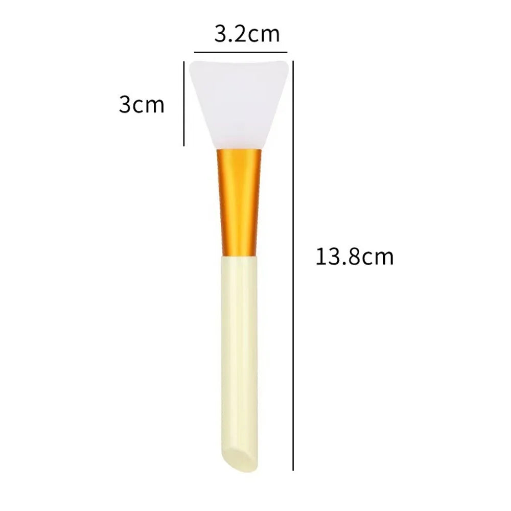 A white silicone facial mask brush with an orange handle shown next to dimension lines.