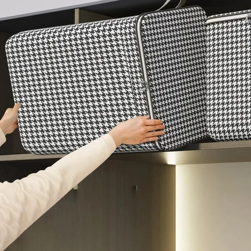 A hand is placing a black and white patterned non-woven quilt storage box onto a shelf.