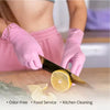 Pink disposable nitrile gloves are shown being used to cut a lemon for kitchen cleaning.